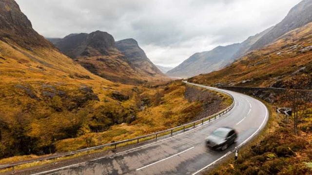 Car driving through Scottish Highlands